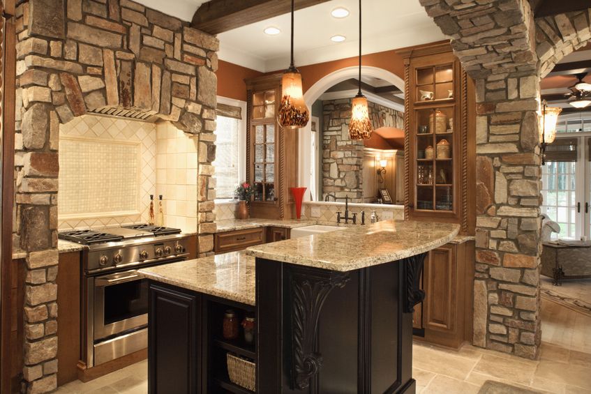 upscale kitchen interior with stone accents and wood beam ceiling.